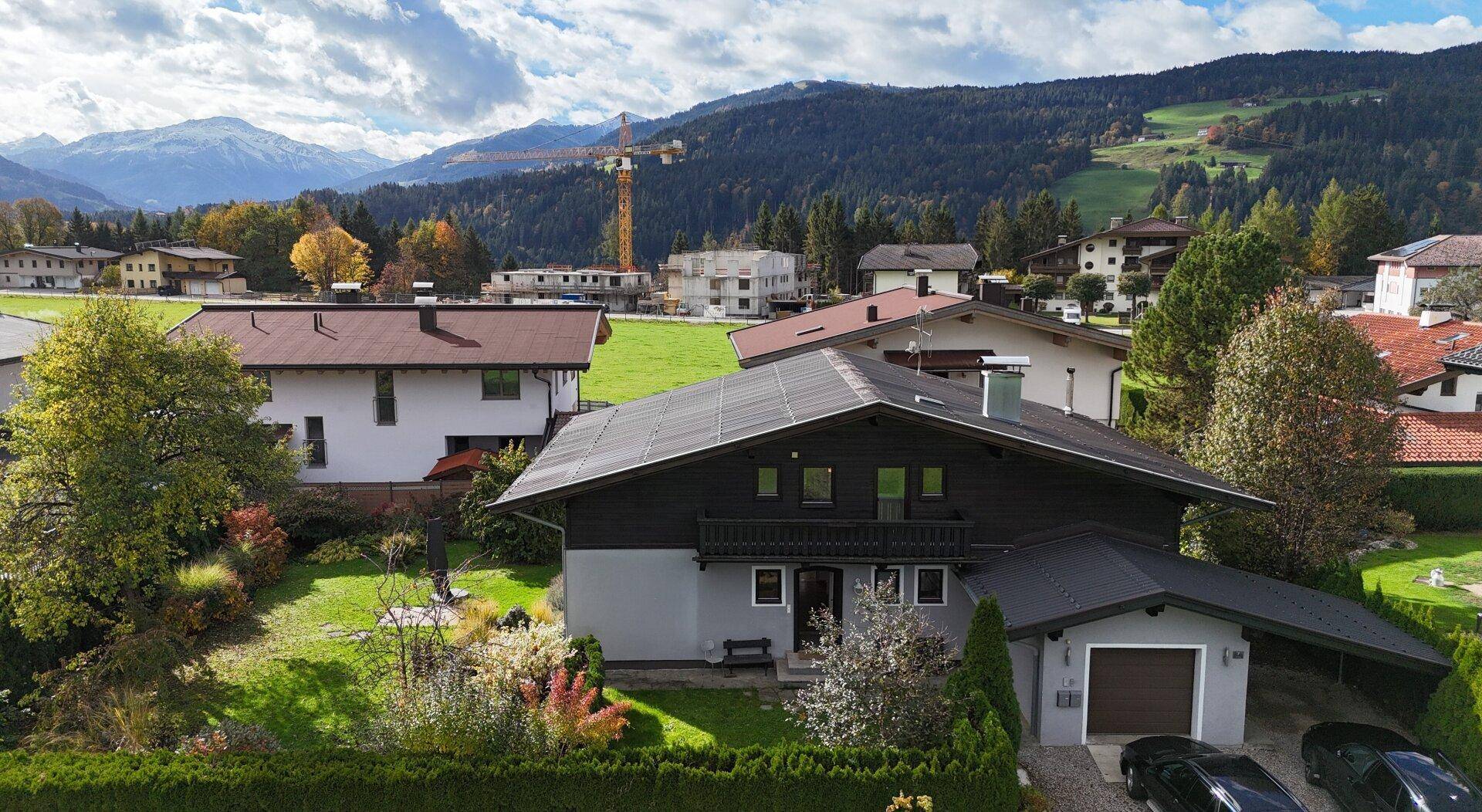 Attraktives Einfamilienhaus mit Photovoltaikanlage, Garten und Bergblick in ländlicher Umgebung.