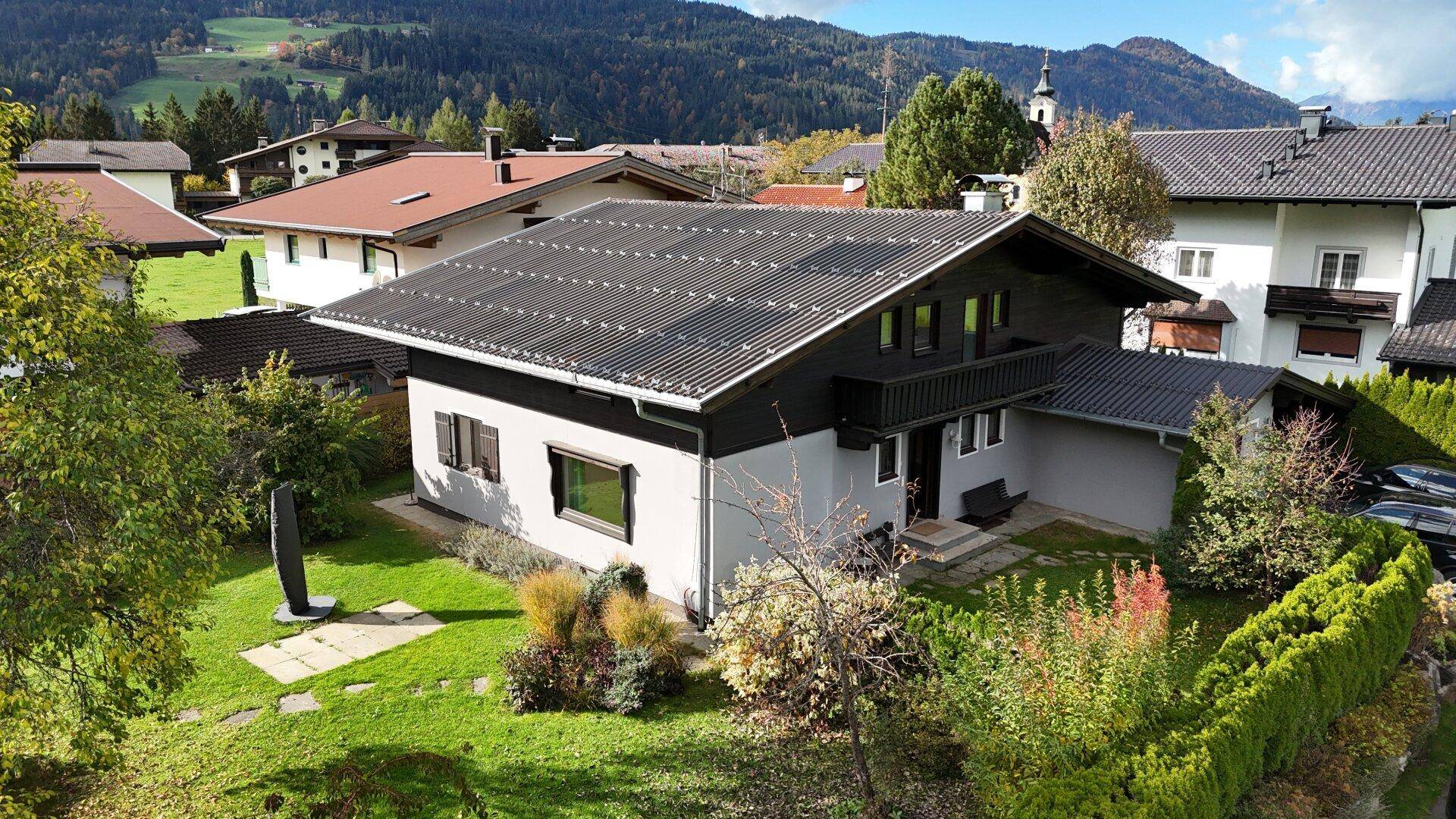 Charmantes Haus mit Photovoltaikanlage, gepflegtem Garten und malerischer Bergkulisse.
