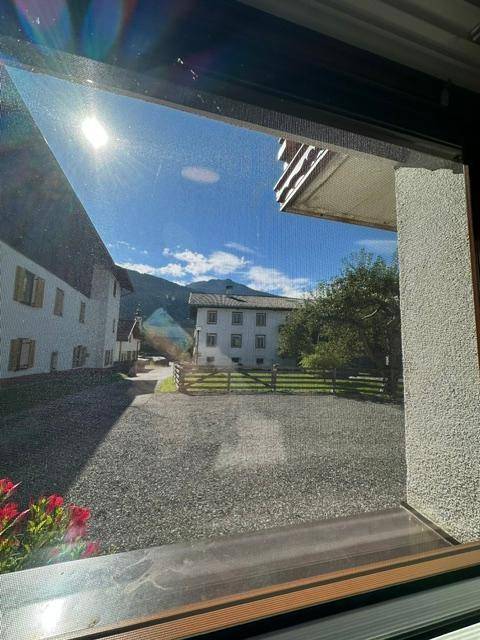 Blick aus dem Fenster auf die umliegende Berglandschaft und traditionelle Gebäude.