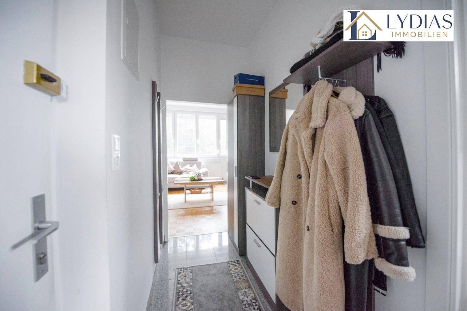 Eingangsbereich mit praktischer Garderobe und Blick in den hellen Wohnbereich.