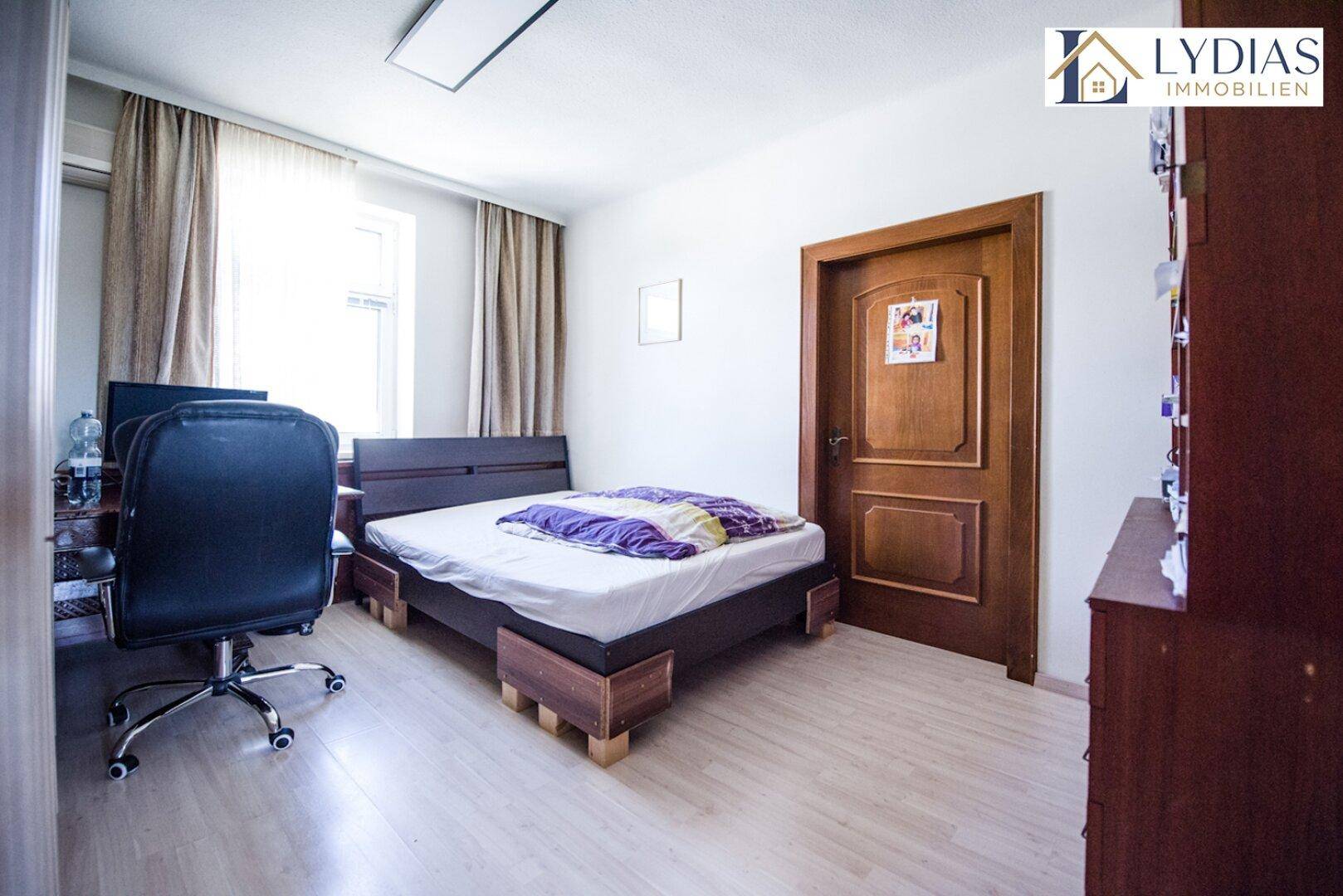 Schlafzimmer mit hellem Boden, Einzelbett und Schreibtisch, ideal als Gästezimmer.