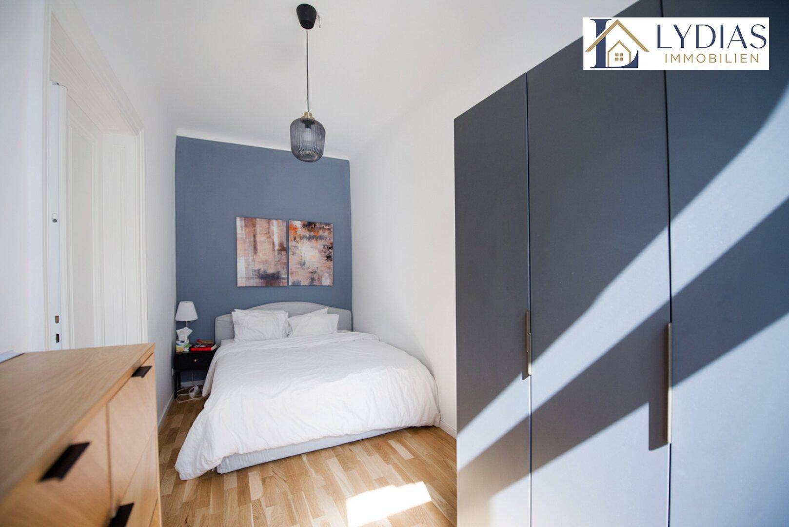 Gemütliches Schlafzimmer mit Holzboden, Doppelbett und modernem Kleiderschrank.