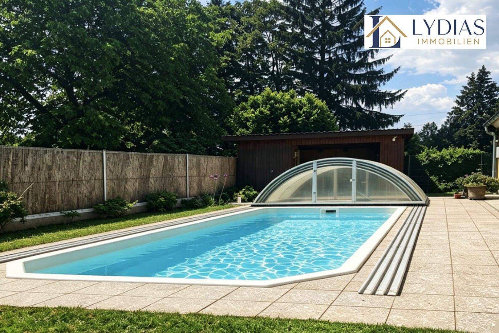 Langer Swimmingpool mit Abdeckung und gepflasterter Terrasse, umgeben von Bäumen und einem Gartenhaus.