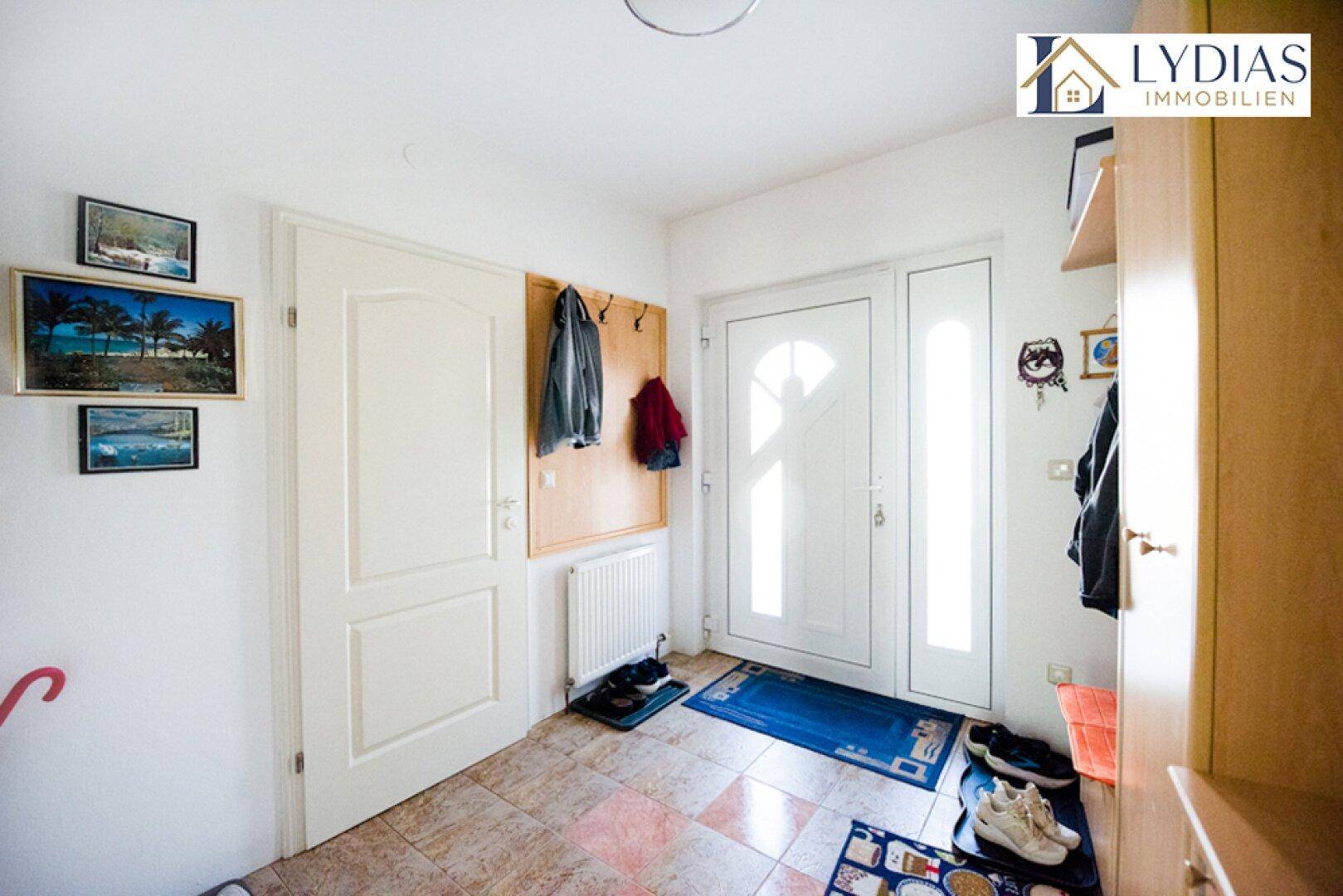 Eingangsbereich mit Fliesenboden, Garderobe und Heizkörper.