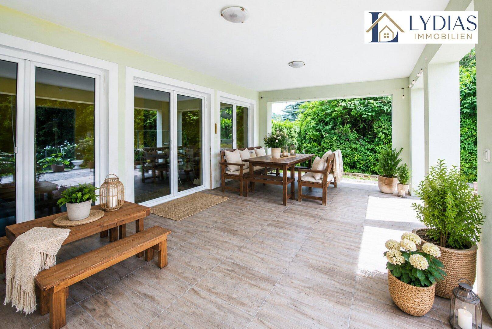Überdachte Terrasse mit Holzbänken und Esstisch, ideal für entspannte Stunden im Freien.
