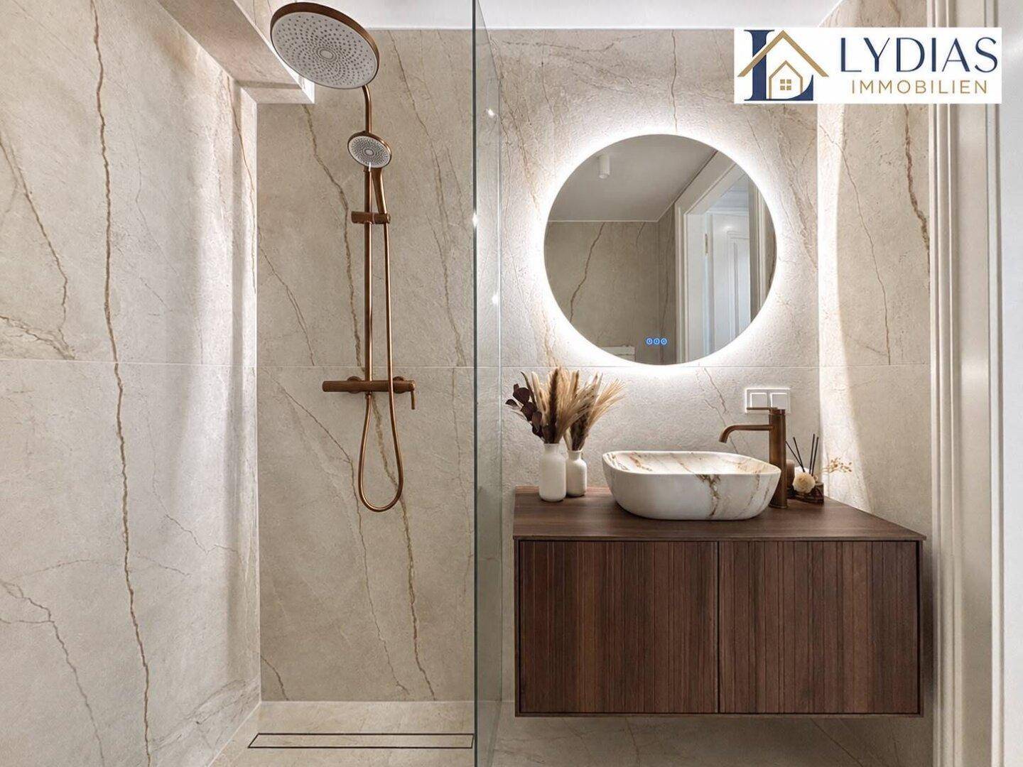 Modernes Badezimmer mit begehbarer Dusche, beleuchtetem Spiegel und eleganten Marmorfliesen.