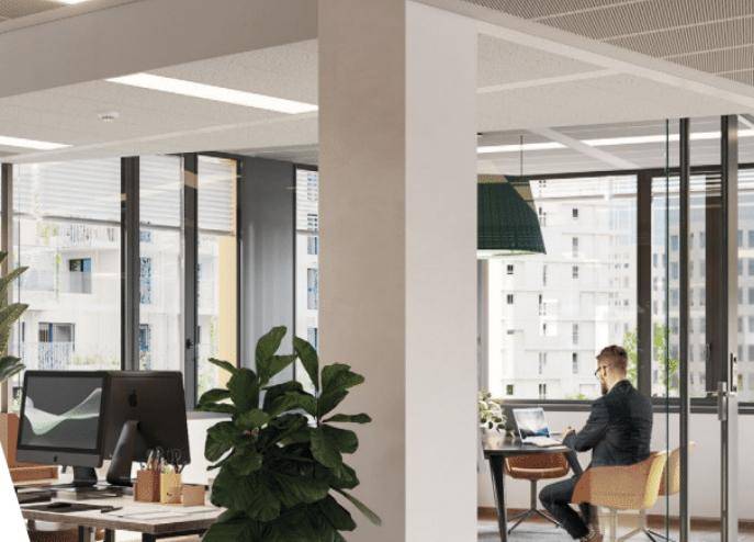 Moderner Arbeitsplatz in einem Büro mit großen Fenstern und Blick auf die Stadt.