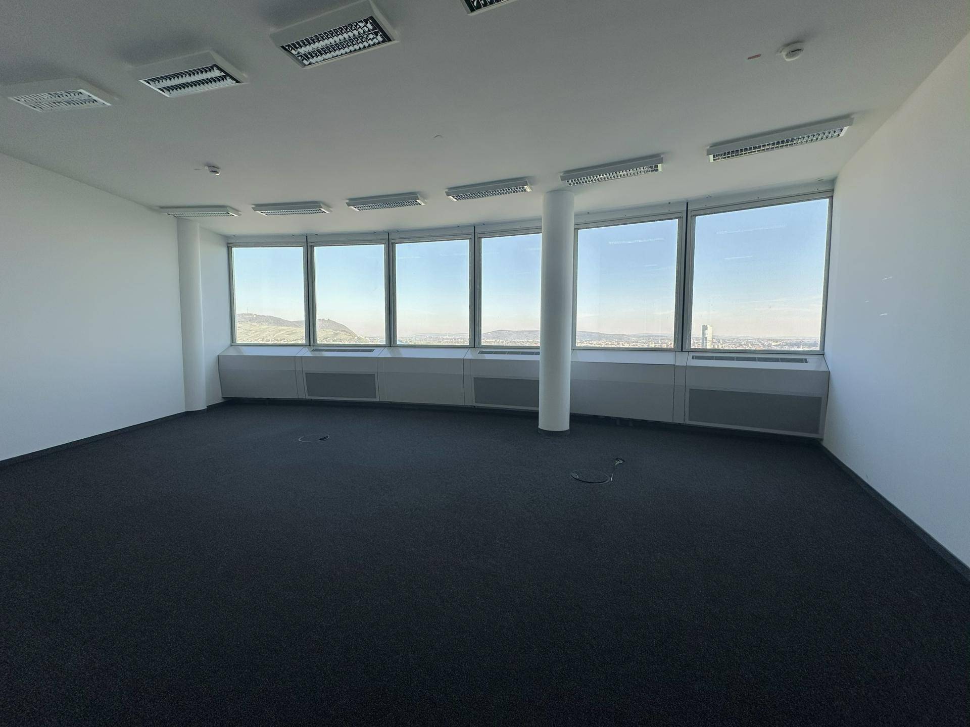Weitläufiges Büro mit durchgehenden Fenstern, die viel Tageslicht und eine beeindruckende Aussicht bieten.