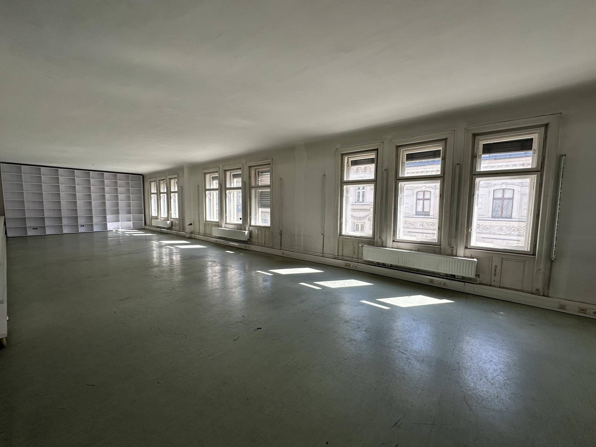 Geräumiger, heller Büroraum mit großen Fenstern und hellem Boden, ideal für offene Arbeitsbereiche.