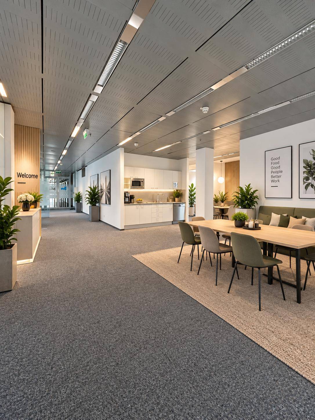 Heller Bürobereich mit moderner Küchenzeile, Esstischen und Pflanzen, ideal für Pausen.