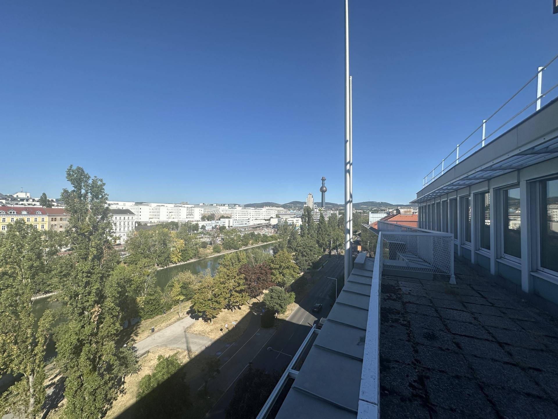 Weitblick über die Stadt und einen Fluss von einem Dachbereich mit Antennen.