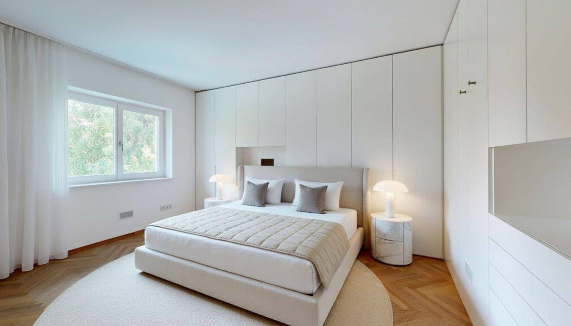 Modernes Schlafzimmer in hellen Tönen mit großem Bett, Einbauschränken und Parkettboden.