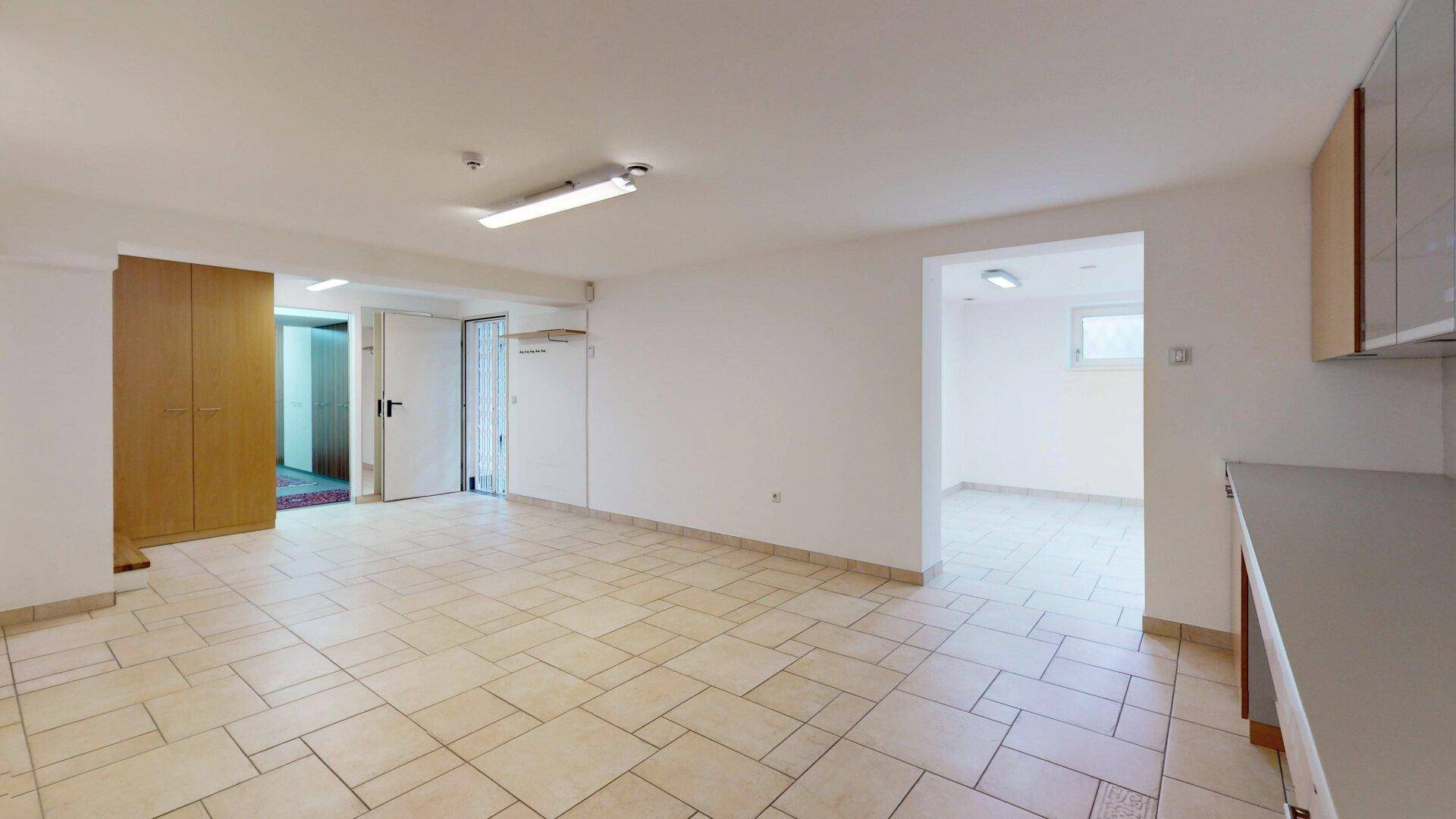 Geräumiger Kellerraum mit Fliesenboden, Einbauschränken und vielseitigen Nutzungsmöglichkeiten.