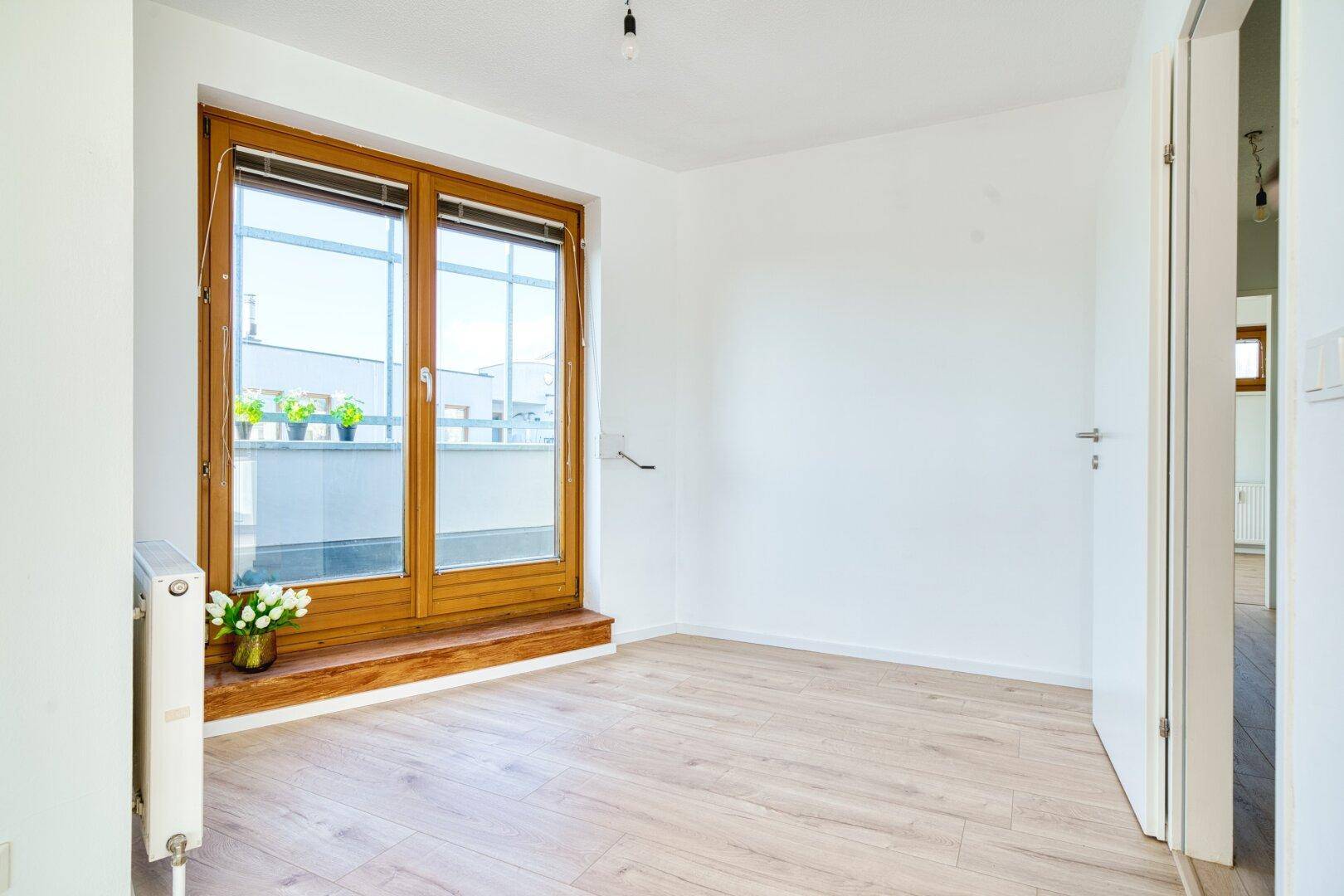 Helles Zimmer mit großen Fenstern und Zugang zum Balkon, ideal als Büro oder Schlafzimmer.