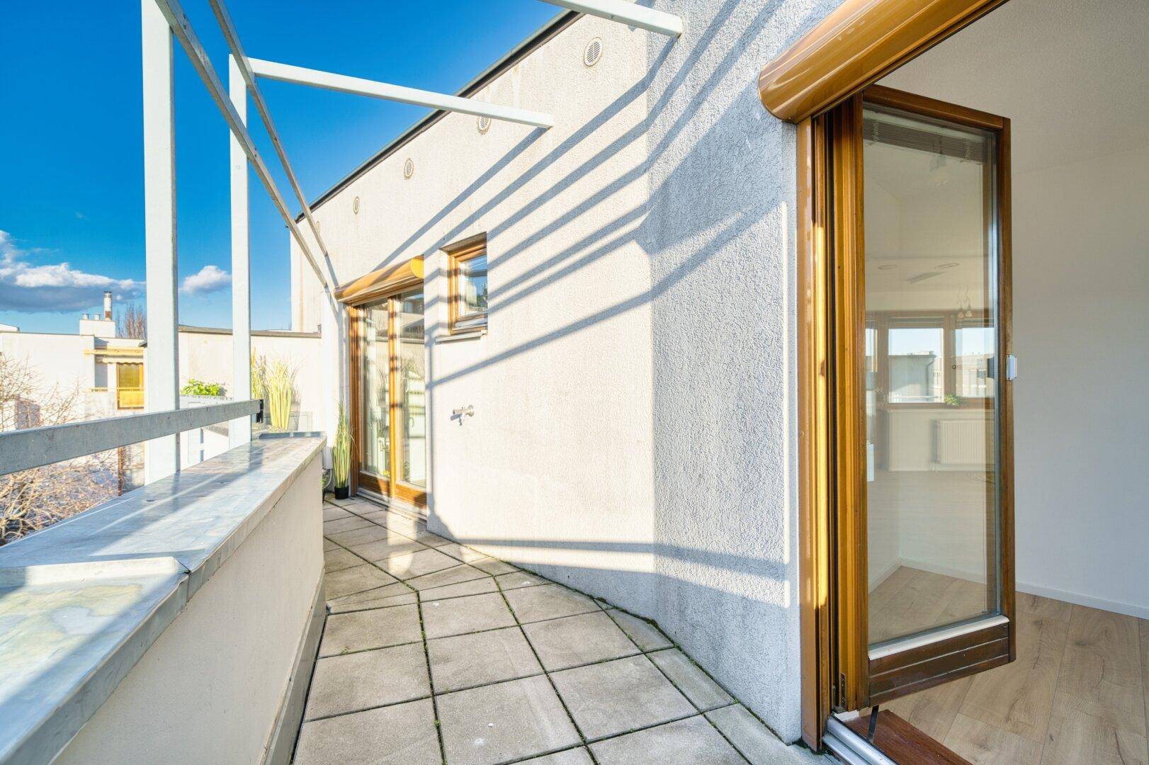 Geräumiger Balkon mit Fliesenboden und Pergola-Struktur, ideal für individuelle Gestaltung.