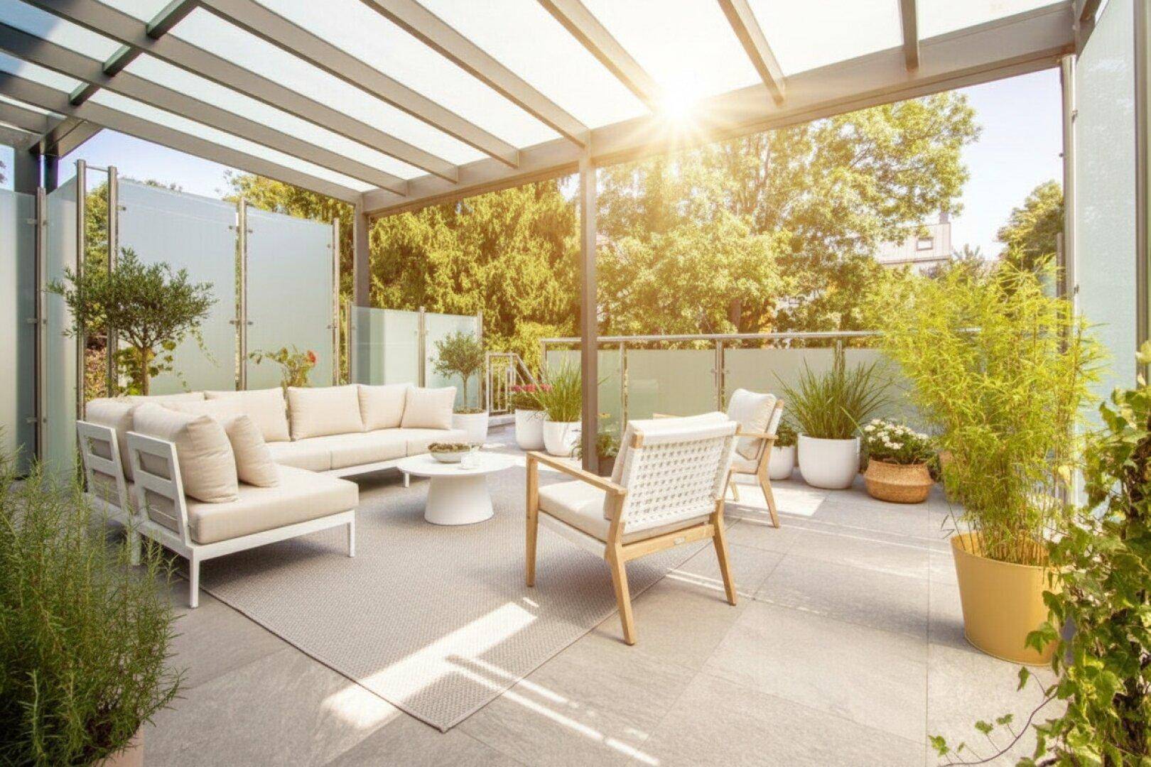 Große, sonnige Terrasse mit moderner Lounge-Möblierung und Blick ins Grüne.