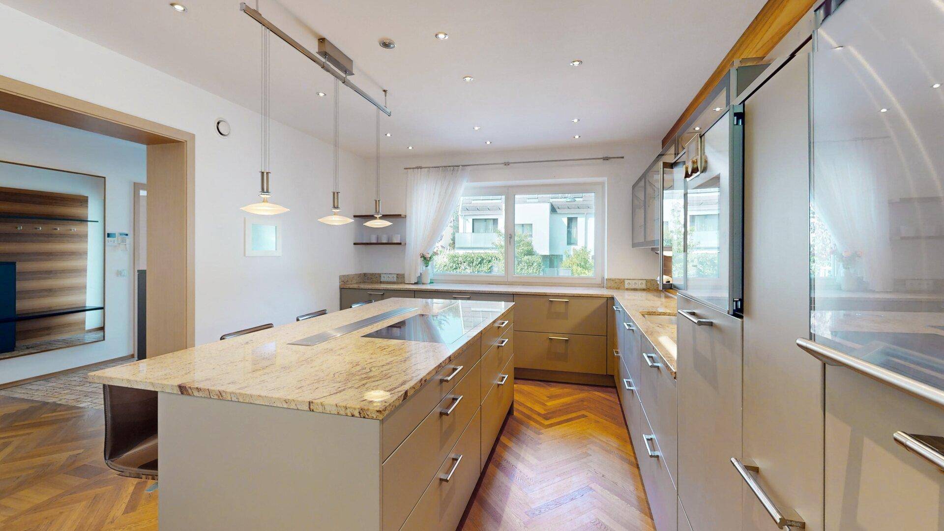 Moderne Küche mit Kücheninsel, Granitarbeitsplatten und integrierten Geräten.