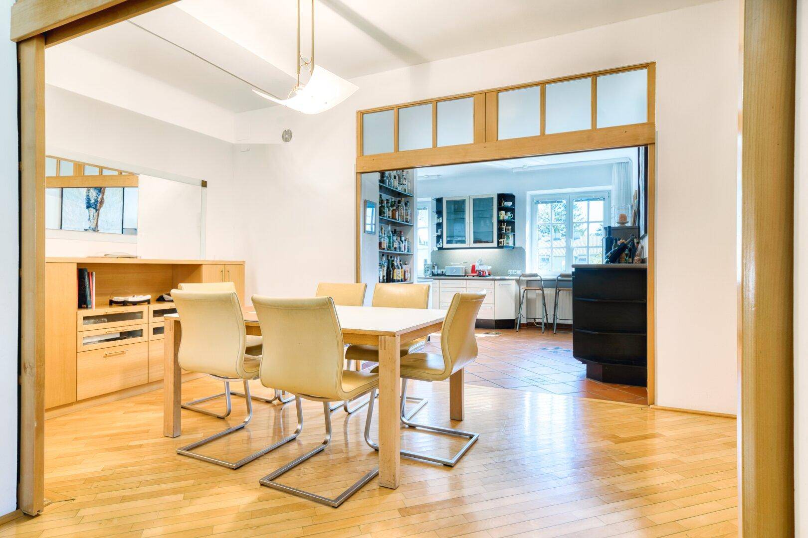 Esszimmer mit Holzboden und Durchgang zur Küche, ideal für gesellige Mahlzeiten.