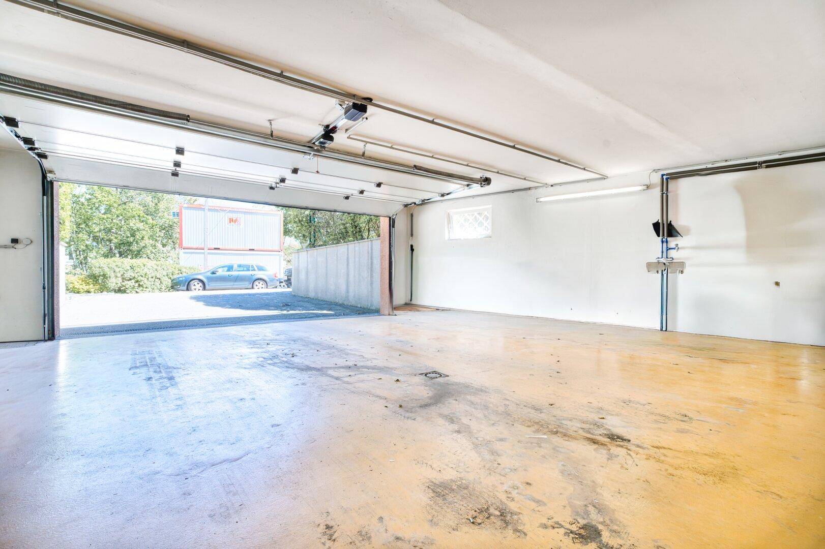 Geräumige Garage mit offenem Tor und Blick auf die Einfahrt.