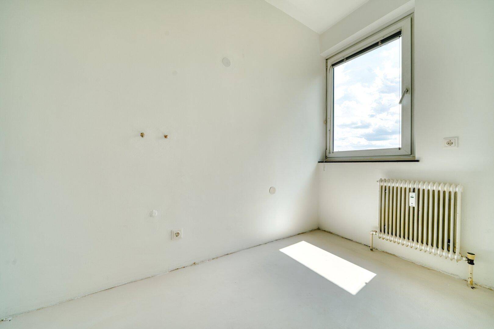 Leeres Schlafzimmer mit weiß gestrichenen Wänden und Fenster.