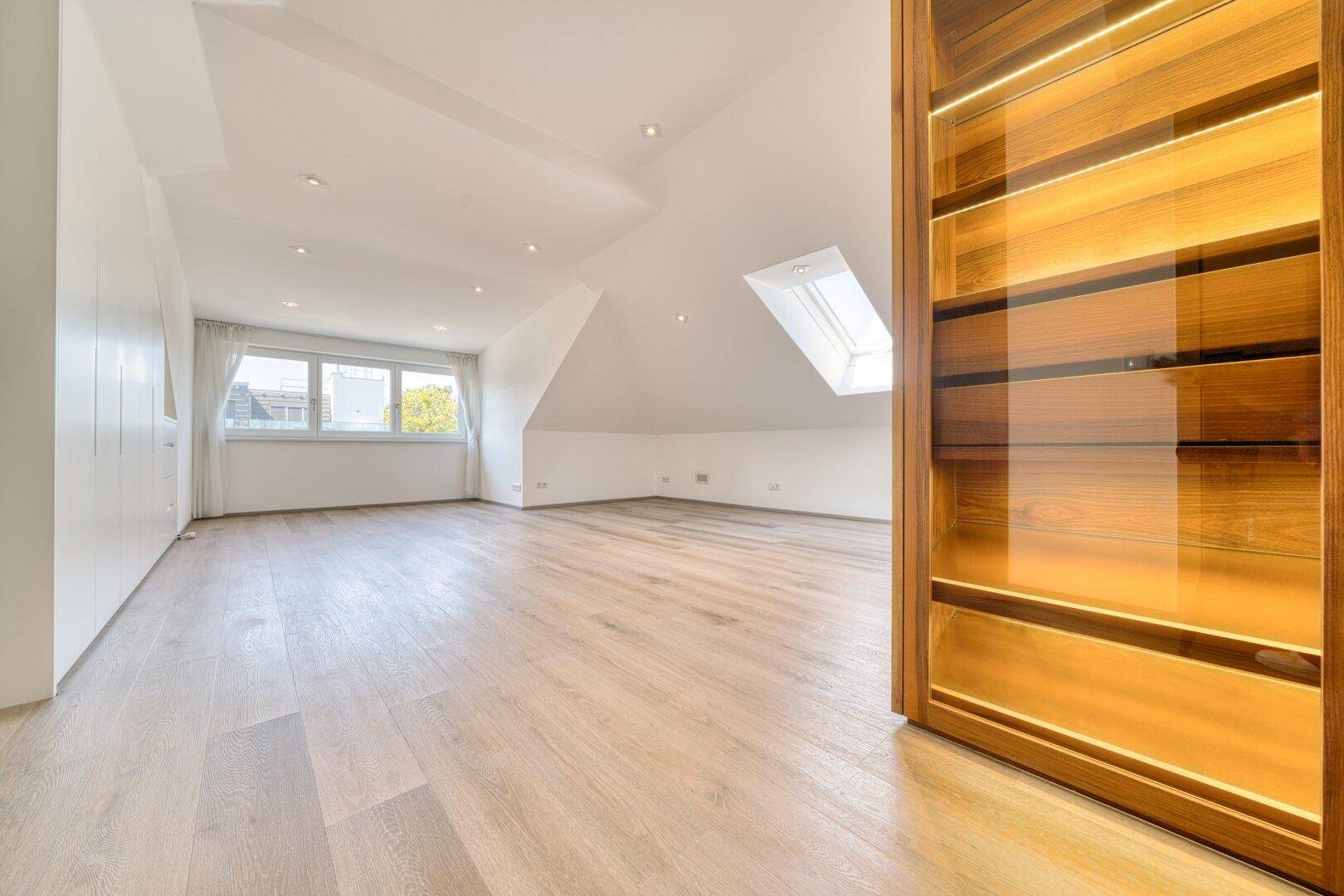 Großzügiger Dachbodenraum mit Holzboden, Dachschrägen und Dachfenster.