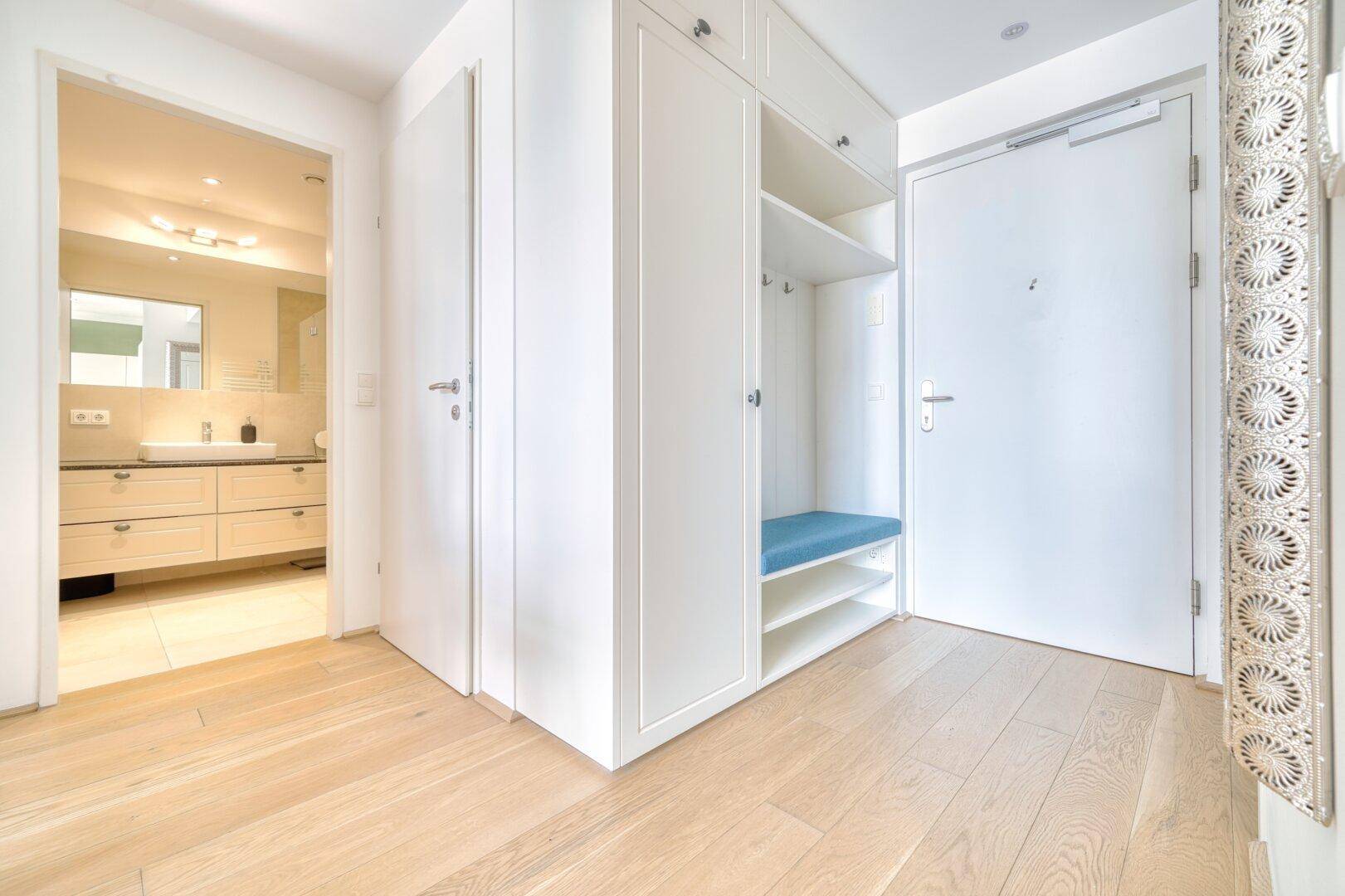 Heller Eingangsbereich mit Einbauschränken und Blick in das angrenzende Badezimmer.