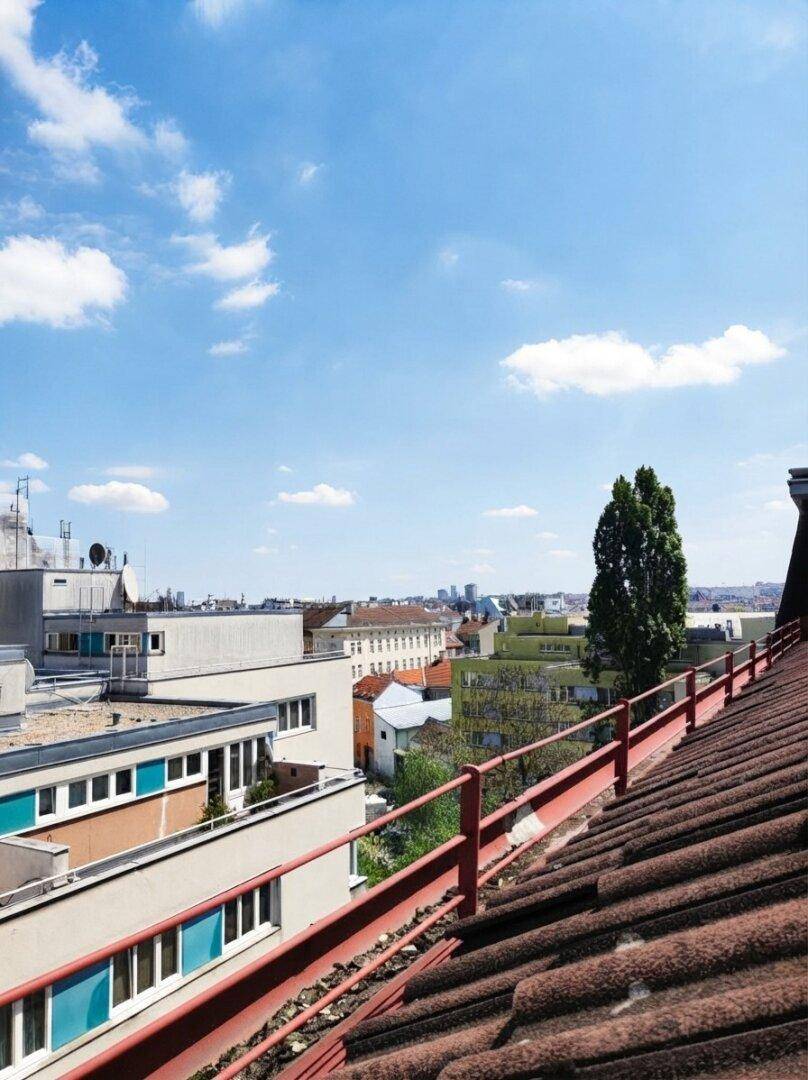 Weitblick über die Dächer der Stadt mit verschiedenen Gebäuden und blauem Himmel an einem sonnigen Tag.
