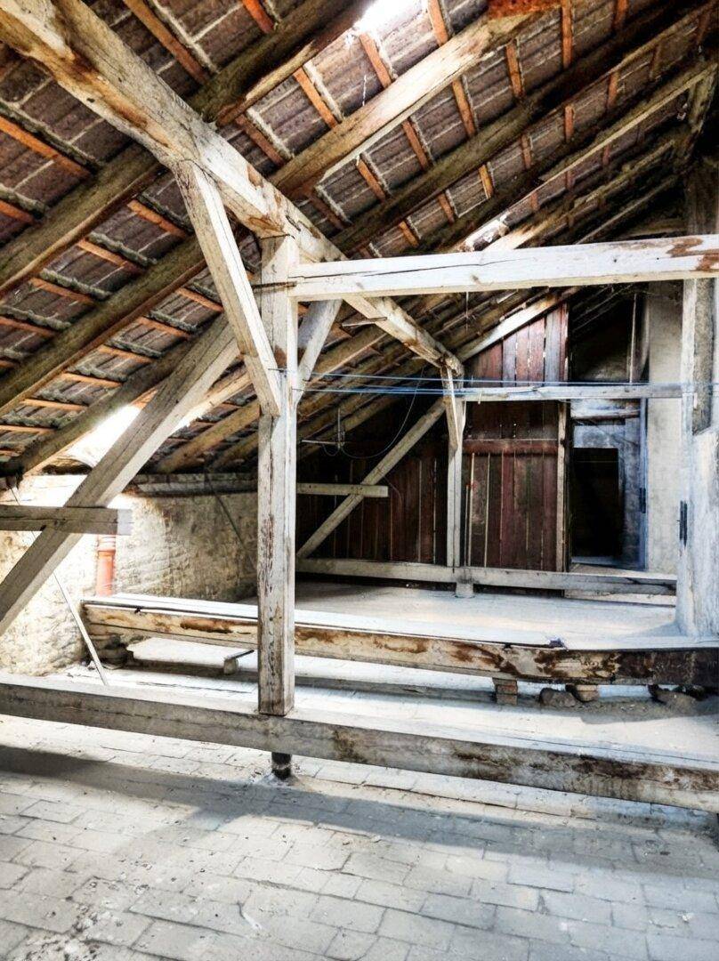 Dachboden mit rustikalen Holzbalken und alten Holzverkleidungen, bereit zur Renovierung und Neugestaltung.
