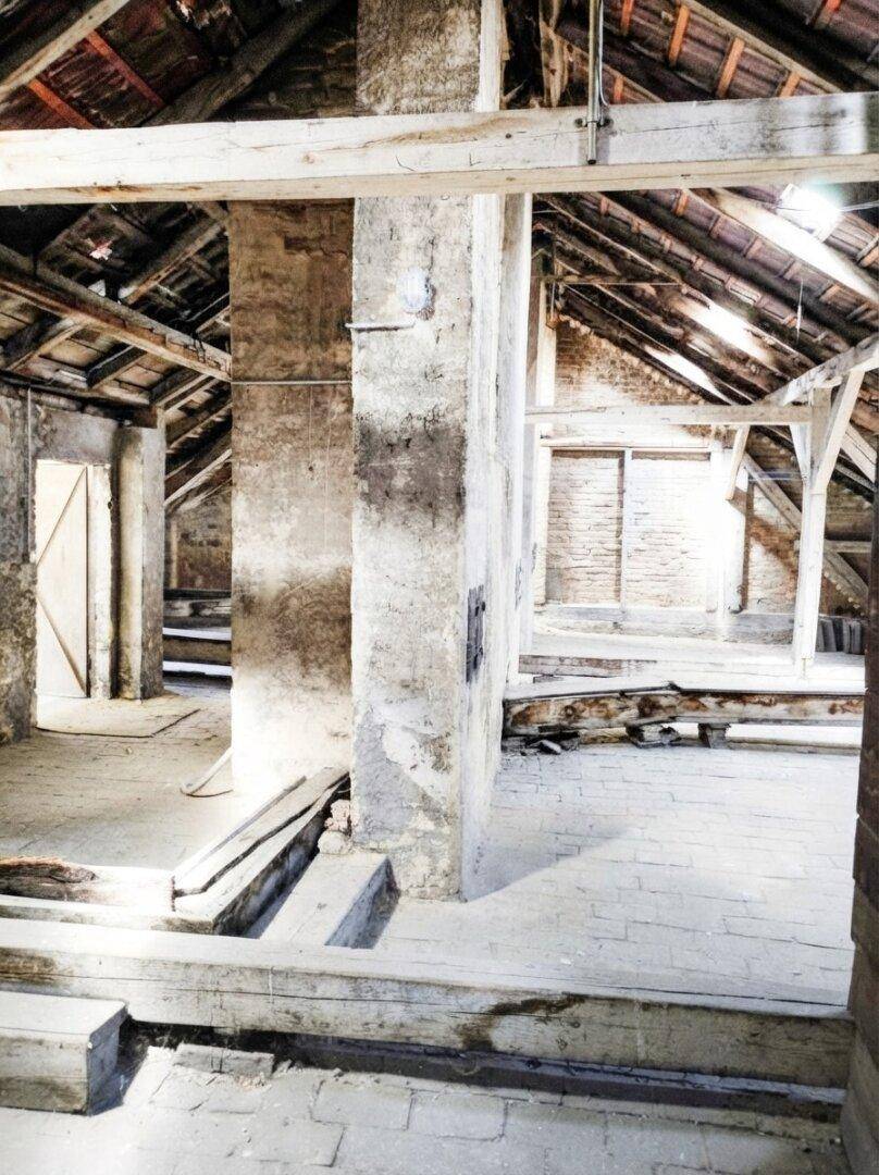 Großer Dachboden mit freiliegenden Ziegelwänden und Holzbalken, ideal für Umbauprojekte.