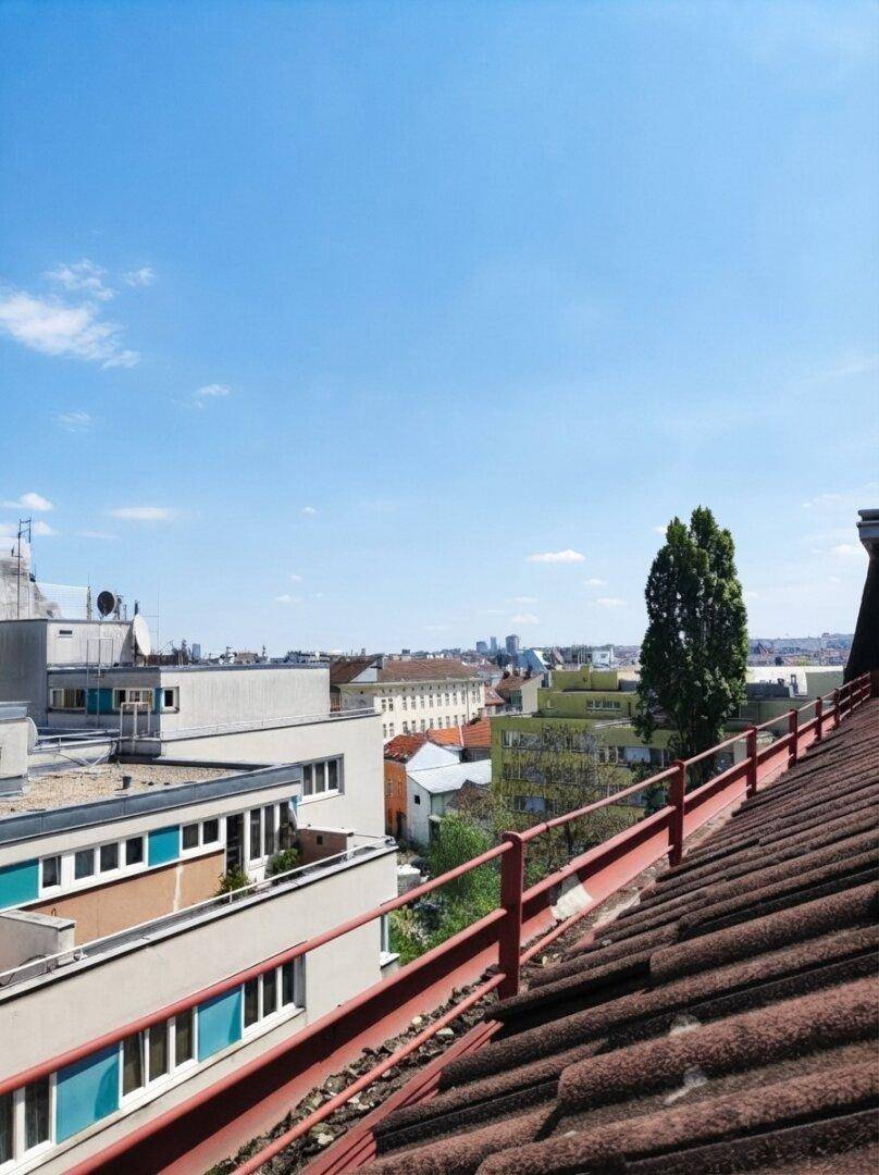 Weitläufiger Blick von den Dächern auf die Stadtlandschaft unter blauem Himmel.