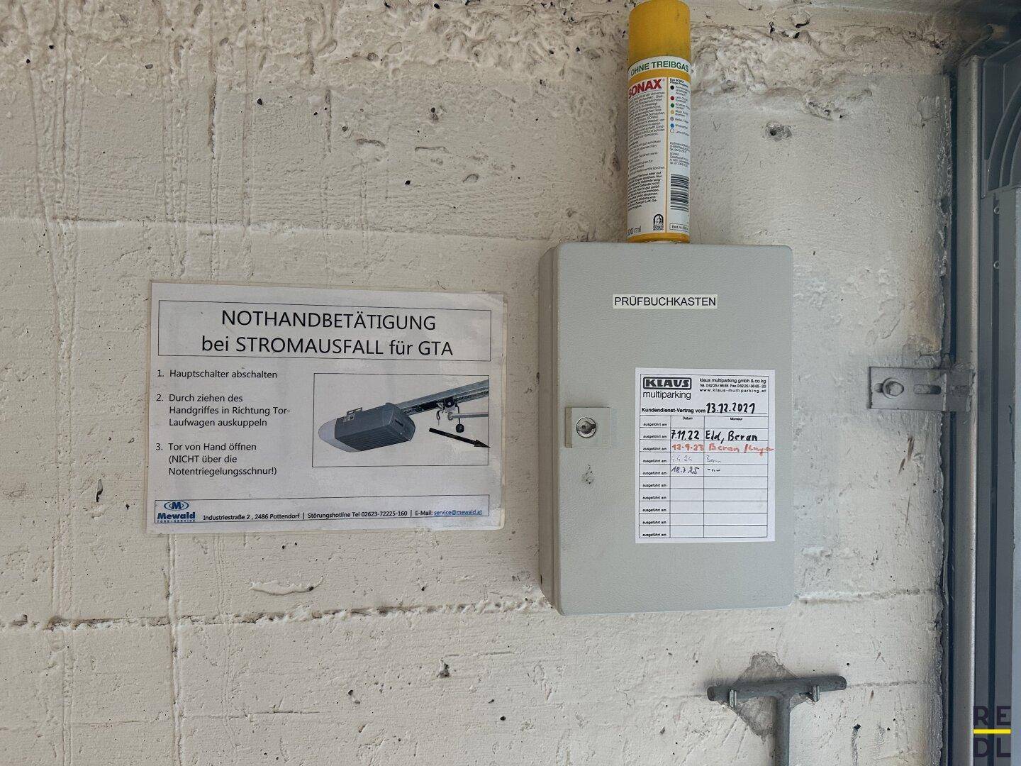 Nahaufnahme eines Prüfbuches und einer Notbetätigungsanleitung für die Tiefgaragensteuerung.