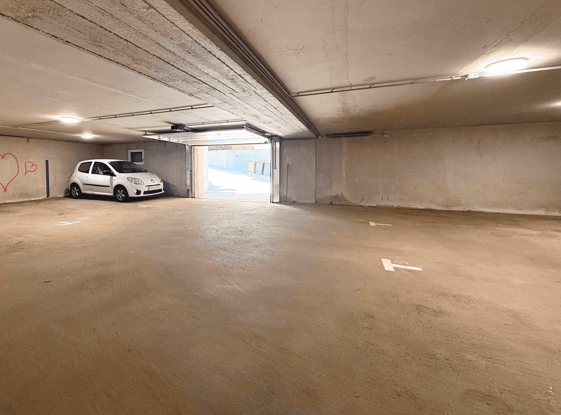 Geräumige Tiefgarage mit Betonboden und ausreichend Platz für mehrere Fahrzeuge.