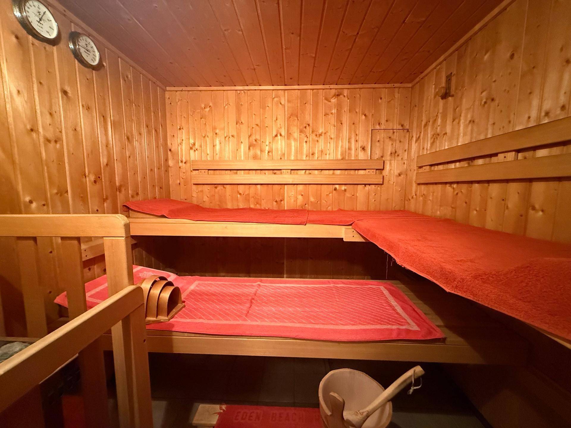 Traditionelle Holzsauna mit mehreren Liegeflächen und klassischem Saunaofen.