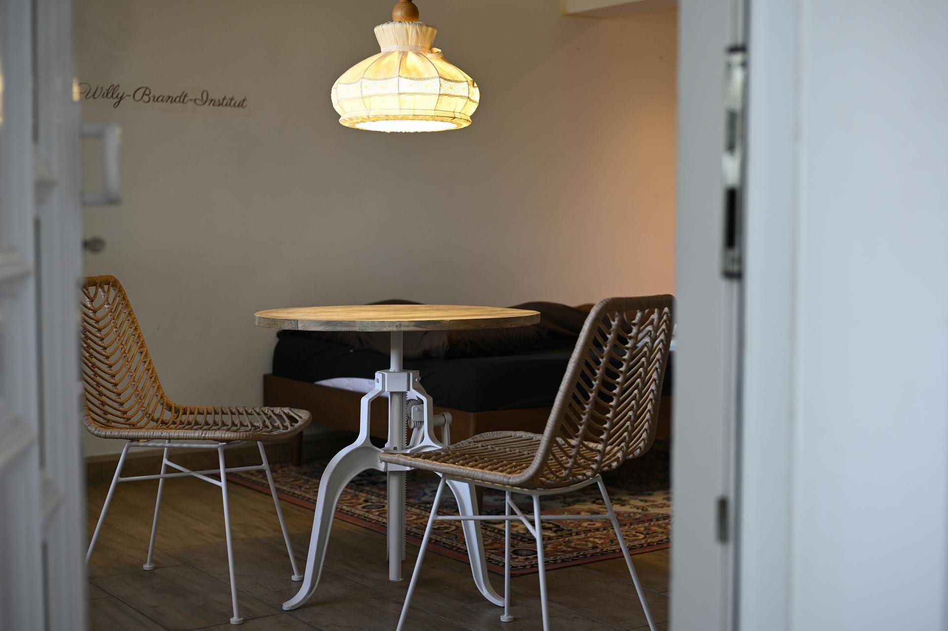 Gemütlicher Schlafbereich mit kleinem Tisch, zwei modernen Stühlen und einer Deckenlampe.