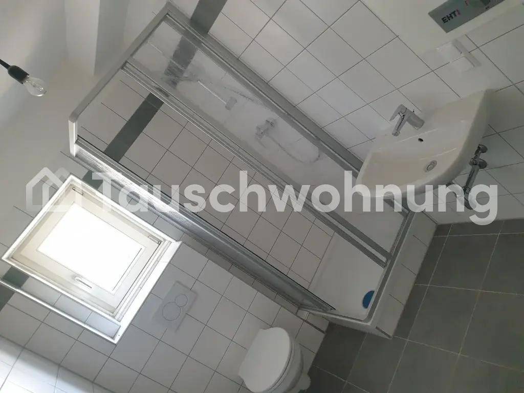 Modernes Badezimmer mit Duschkabine, Waschbecken und Toilette, hell gefliest.
