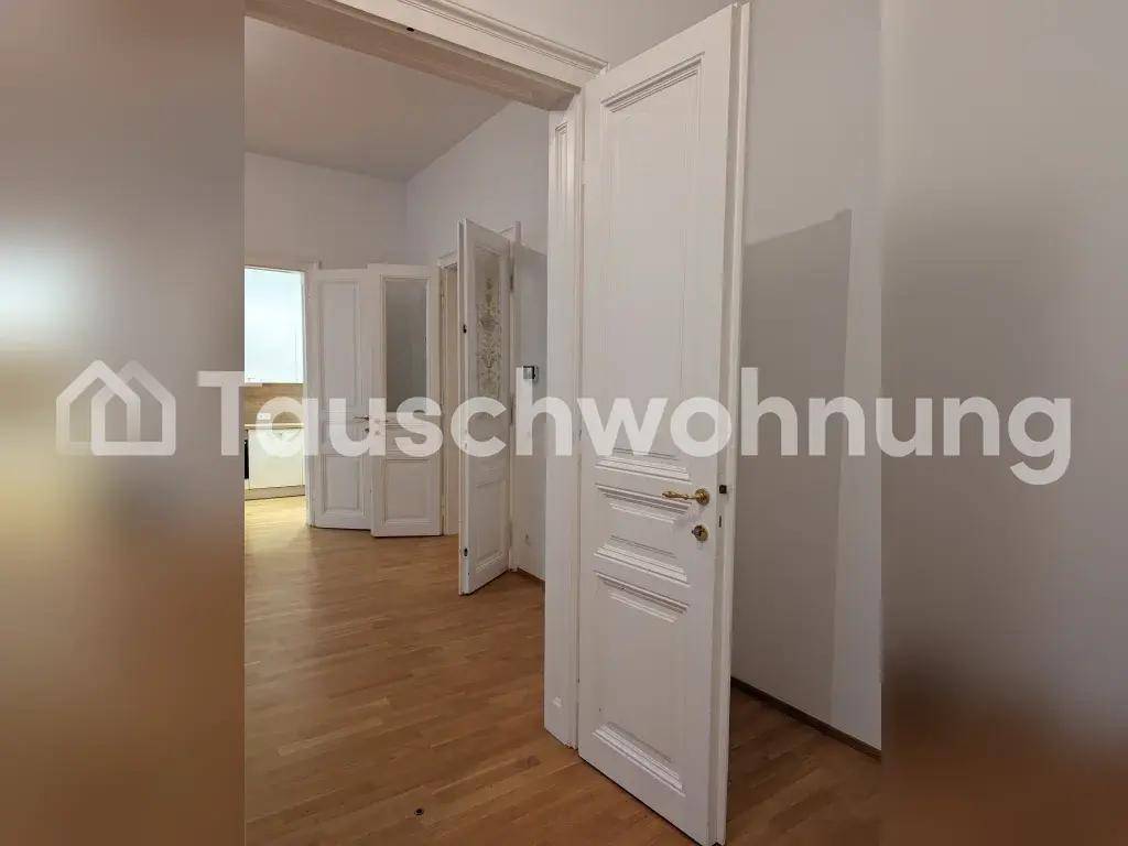 Heller Innenraum mit klassischen weißen Türen und Holzboden, der zu weiteren Räumen führt.