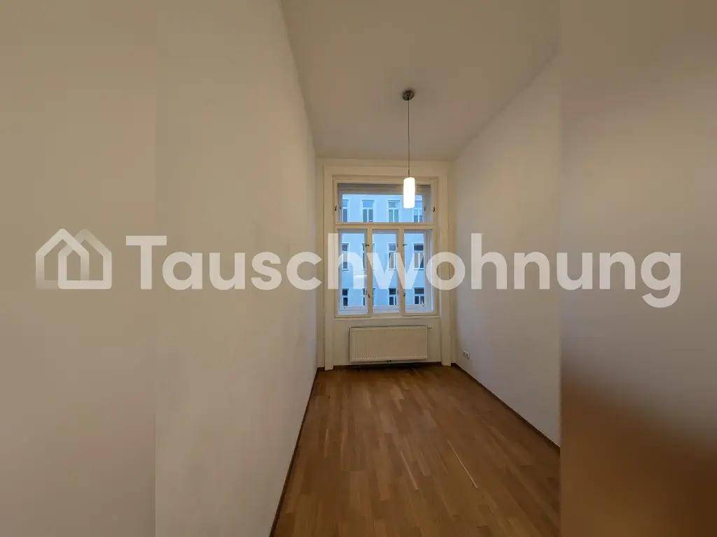 Leerer Raum mit Holzboden, einem Fenster und einem Heizkörper darunter.