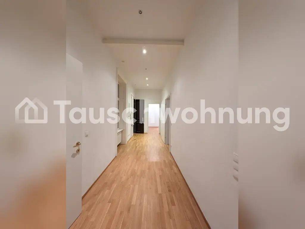 Langer, heller Flur mit Holzboden und moderner Deckenbeleuchtung.