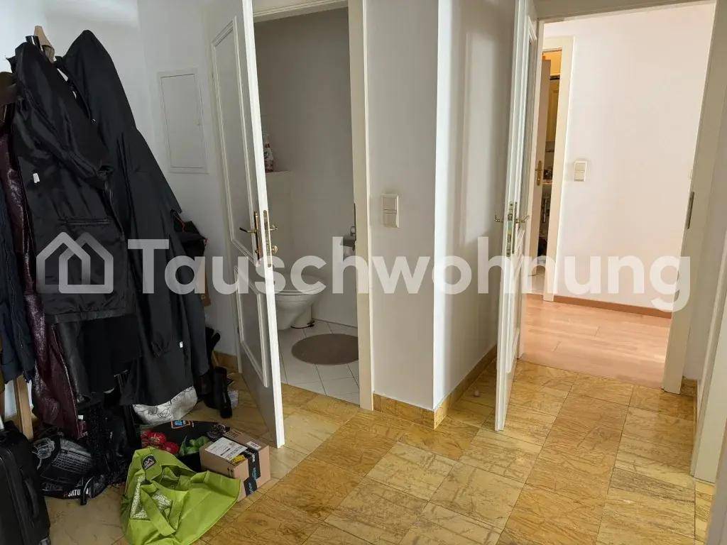 Flur mit Garderobe und Zugang zu einem separaten Gäste-WC mit einfacher Ausstattung.