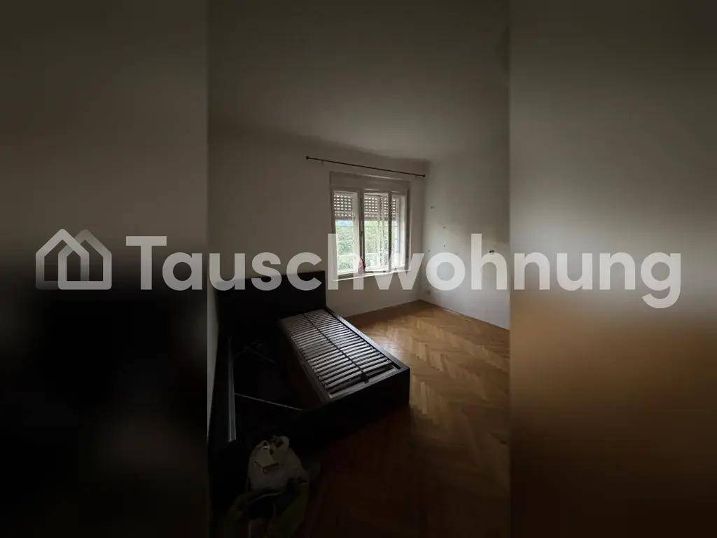Helles Zimmer mit Fischgrätparkettboden und einem Fenster, das viel Licht hereinlässt.