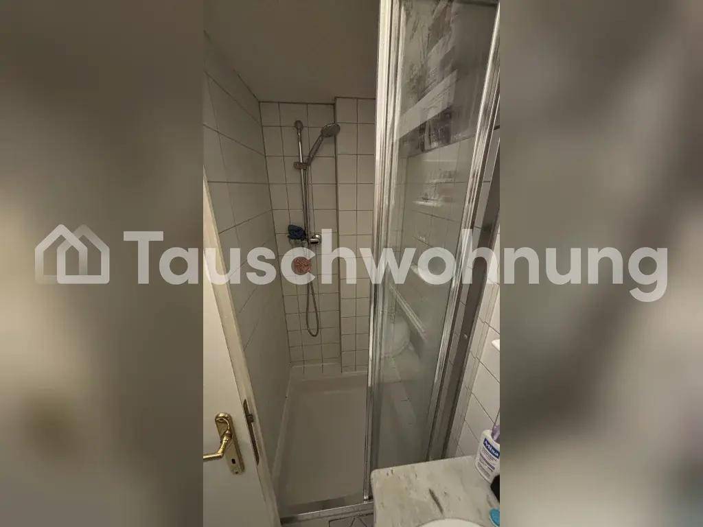 Duschkabine mit weißen Fliesen und einer Glastür, die eine funktionale Dusche bietet.