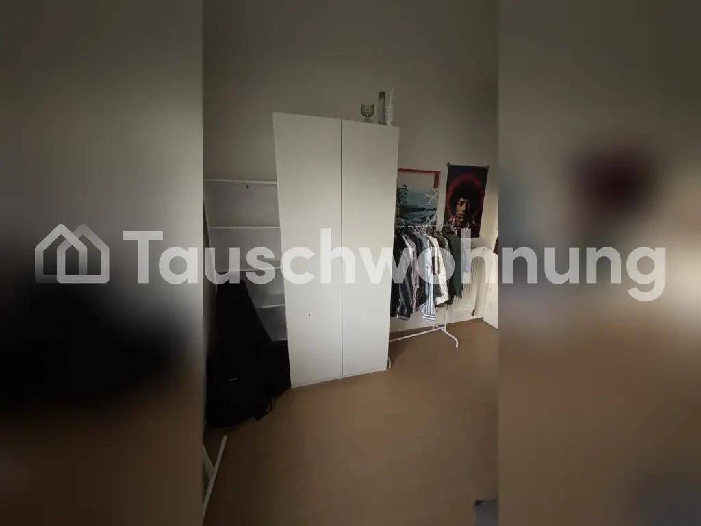 Schlafzimmerbereich mit einem weißen Kleiderschrank und einem praktischen Kleiderständer.