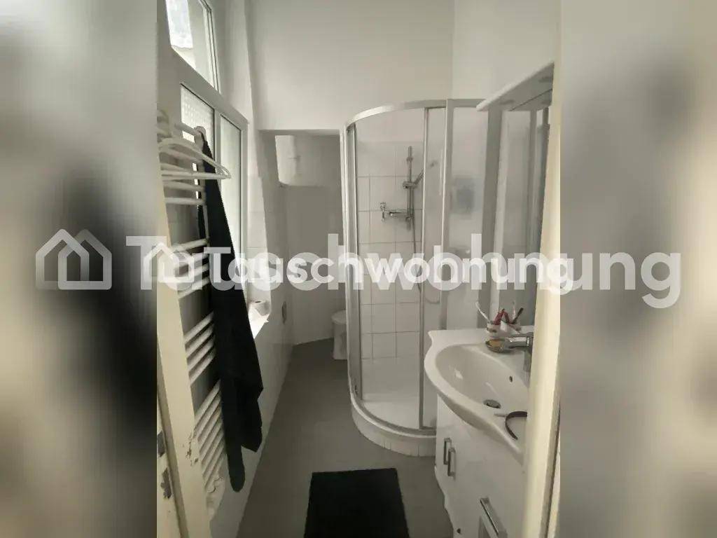 Kleines Badezimmer mit Duschkabine, Waschbecken und beheiztem Handtuchhalter.