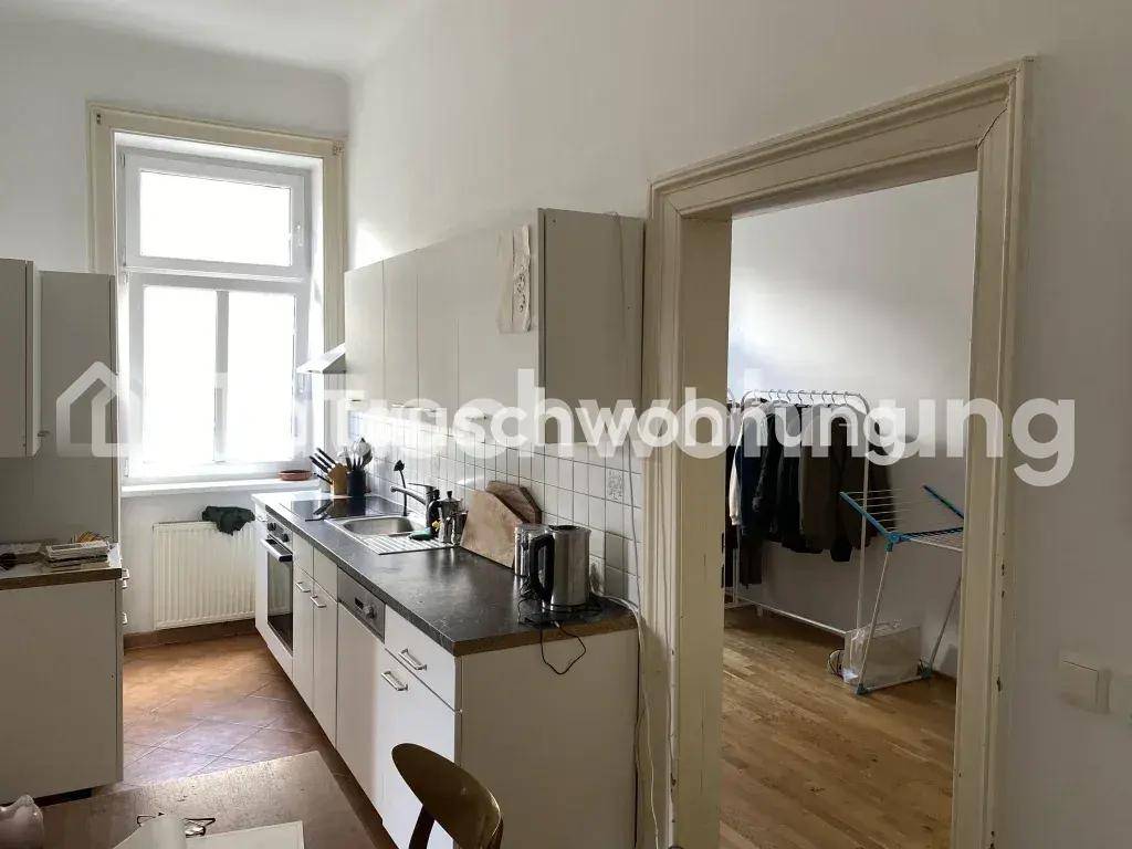 Helle Küche mit weißen Unterschränken, Spüle und Blick aus dem Fenster.