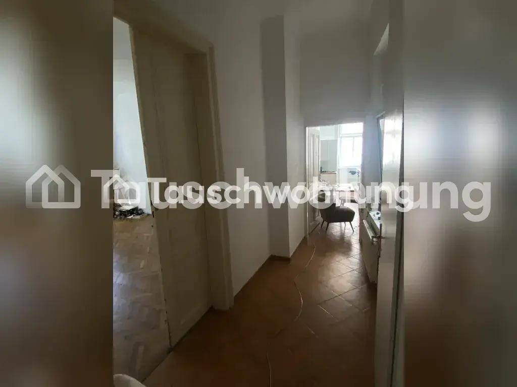 Langer Flur mit Fliesenboden und Durchgang zu weiteren Zimmern der Wohnung.
