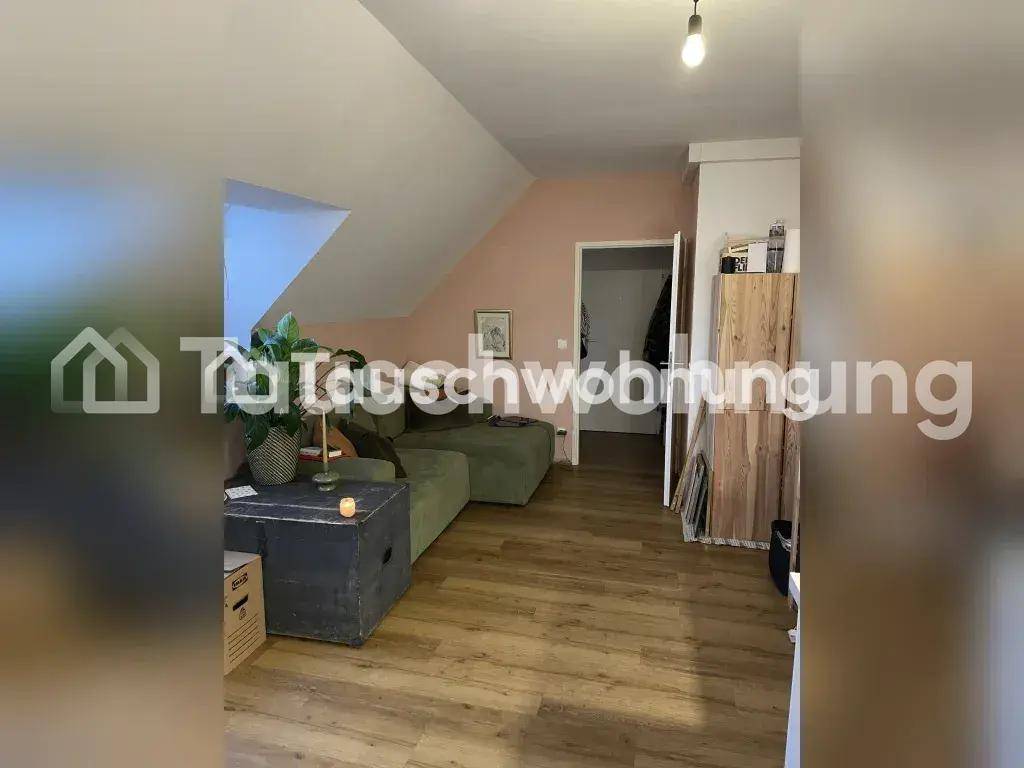 Heller Wohnbereich mit Sofa und Dachschrägen, der zu einem weiteren Raum führt.
