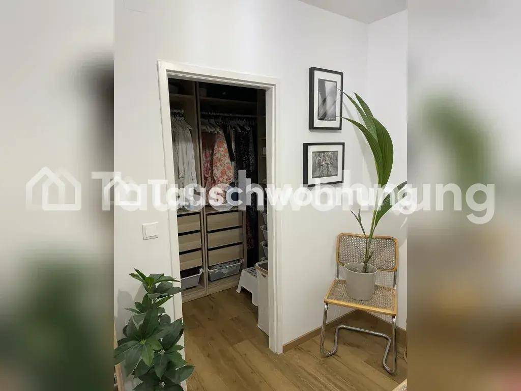 Offener Kleiderschrankbereich im Flur mit Stauraum und Dekoration.