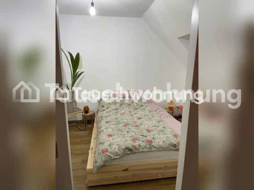 Schlafzimmer mit Holzbett und Dachschrägen, einfach und funktional eingerichtet.