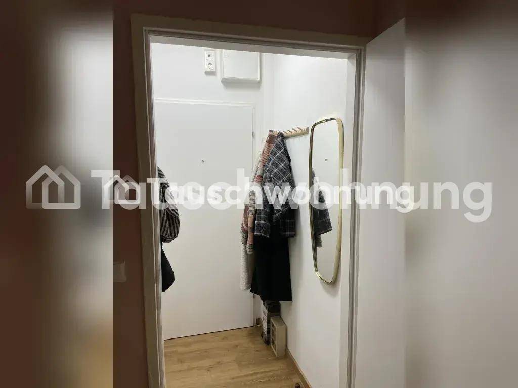 Eingangsbereich mit Garderobe und Spiegel, funktional und hell gestaltet.