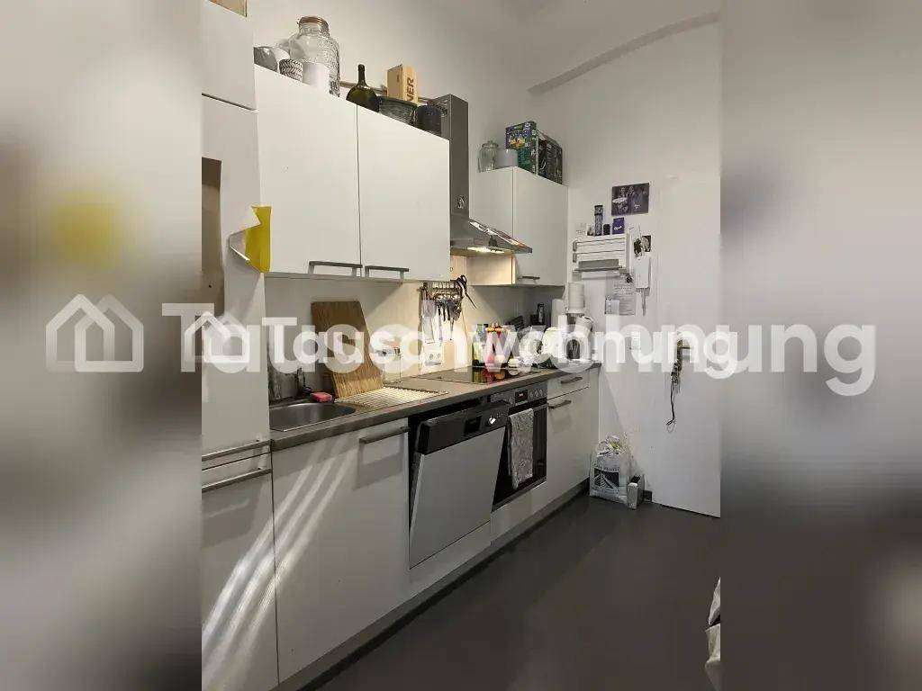 Moderne Einbauküche mit weißen Schränken, Spülmaschine und Dunstabzugshaube.